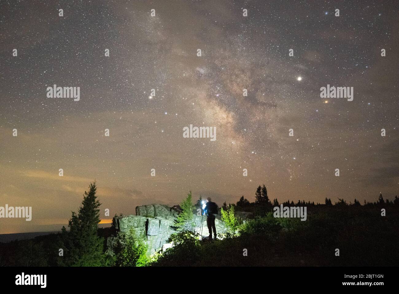 Un photographe de ciel nocturne installe l'appareil photo pour prendre un cliché de la manière laiteuse au-dessus du paysage rocheux sur Dolly Sods en Virginie occidentale. Banque D'Images