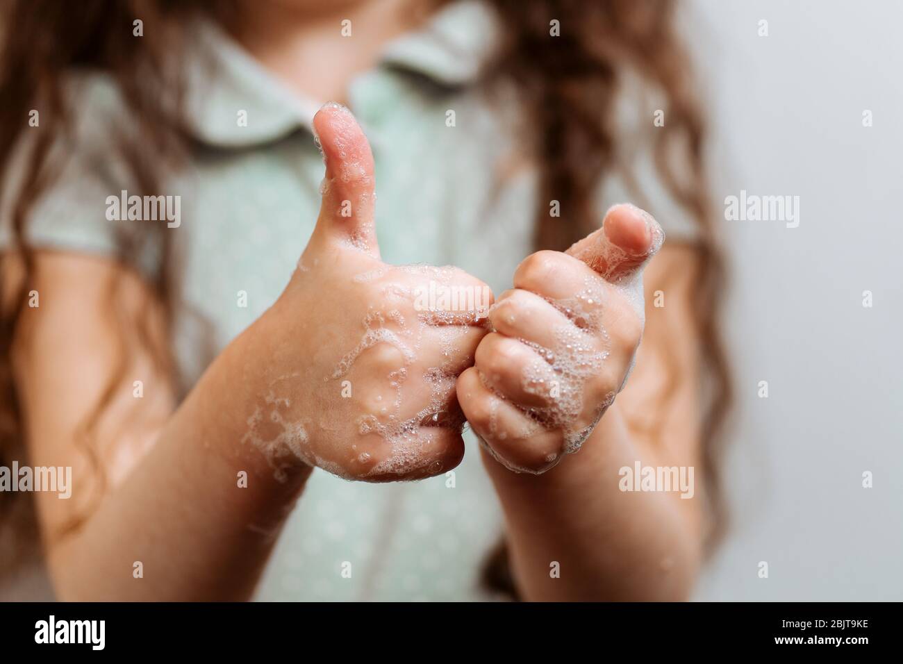 Mains pour enfants en mousse savonneuse. N'oubliez pas de se laver les mains Banque D'Images