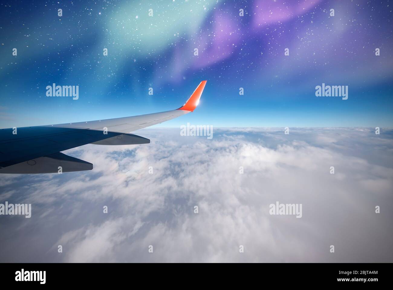 Avion au-dessus du nord, aurores ou lumières du nord de la fenêtre d'avion, aurore Borealis, ciel nocturne avec nuages et étoiles Banque D'Images