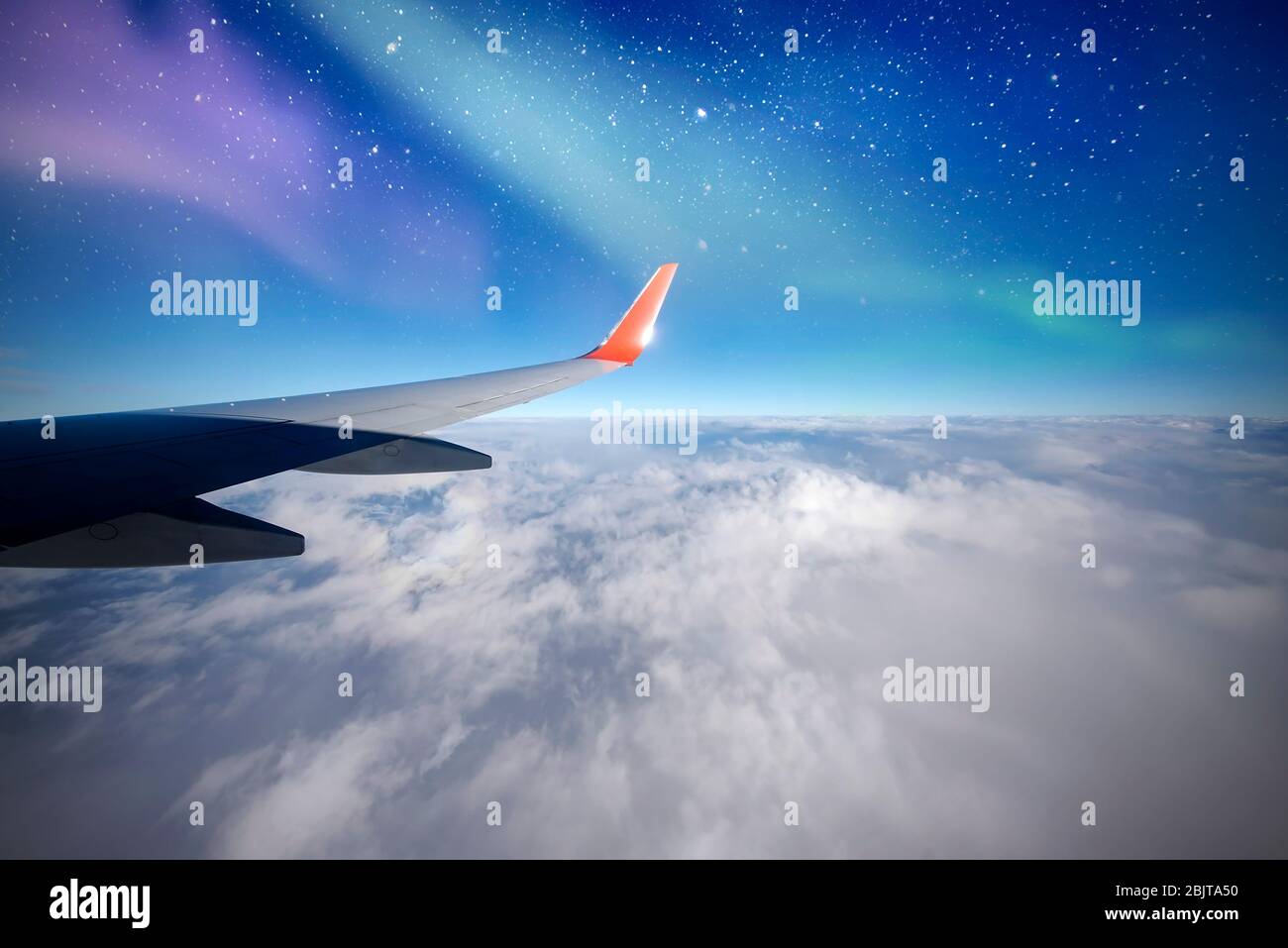 Avion au-dessus du nord, aurores ou lumières du nord de la fenêtre d'avion, aurore Borealis, ciel nocturne avec nuages et étoiles Banque D'Images