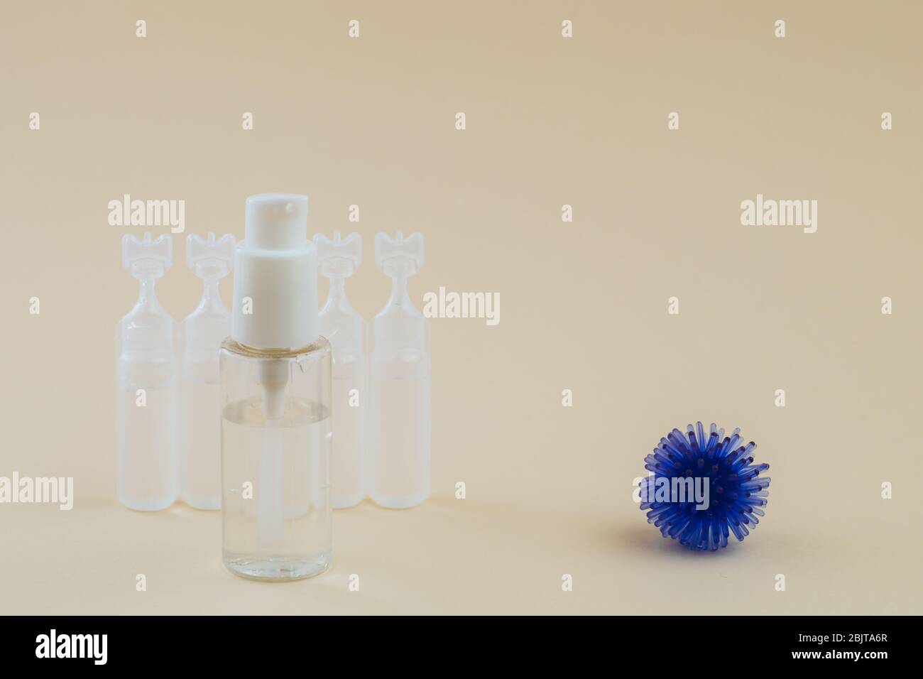 Modèle abstrait de coronavirus, ampoule avec médicament et flacon avec gel antibactérien pour les mains sur fond beige. Concept d'hygiène. Banque D'Images