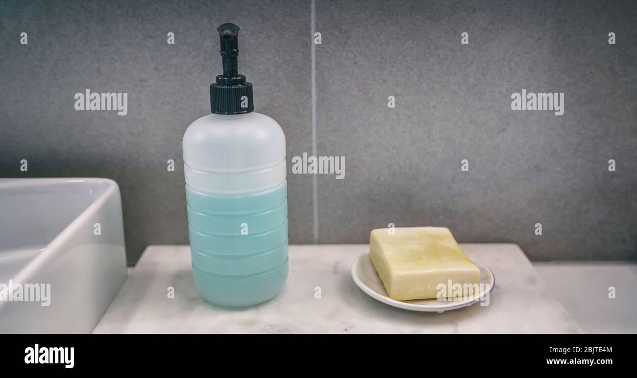 Savon-bar contre savon liquide de savon à main comparaison des produits de lavage des mains sur la maison salle de bains meuble-lavabo comptoir bannière arrière-plan. Banque D'Images