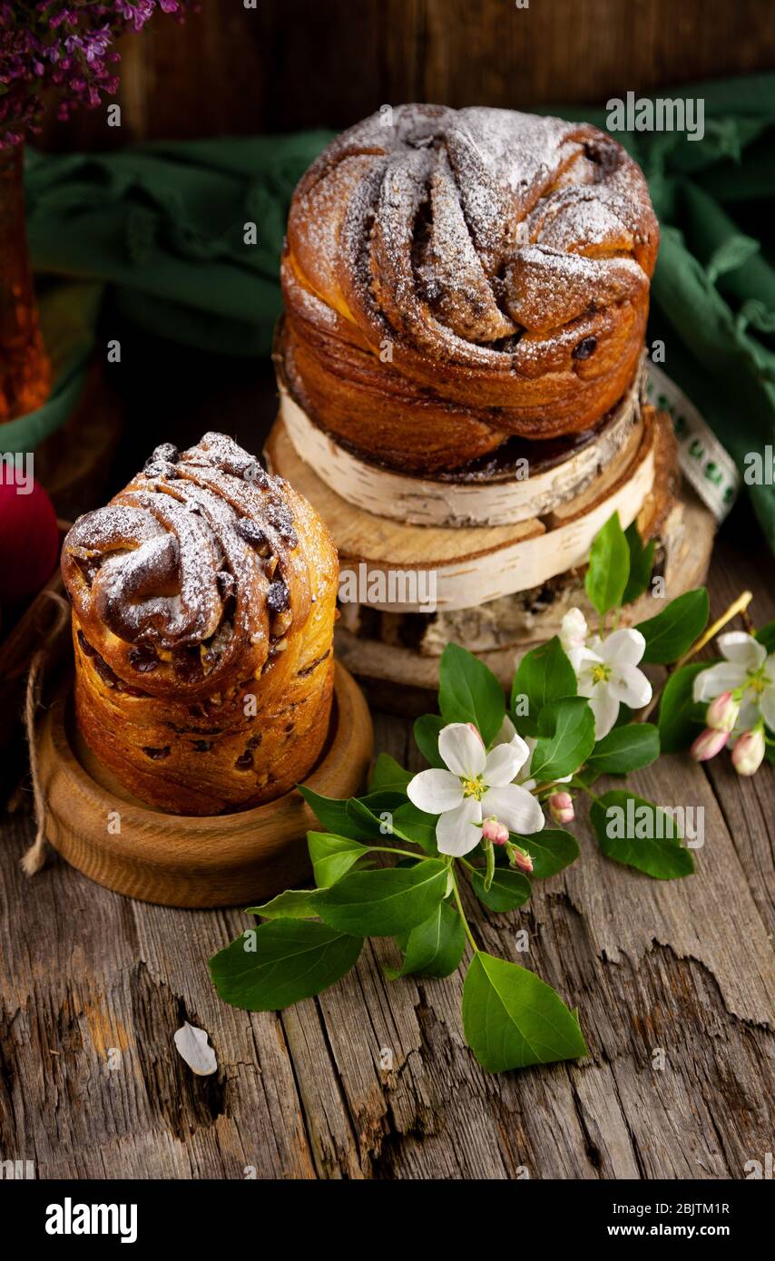 Kraffin gâteau de Pâques. Kraffins aux raisins secs, fruits confits et graines de pavot, arrosés de sucre en poudre. Gros plan de gâteau maison. Brut. Banque D'Images