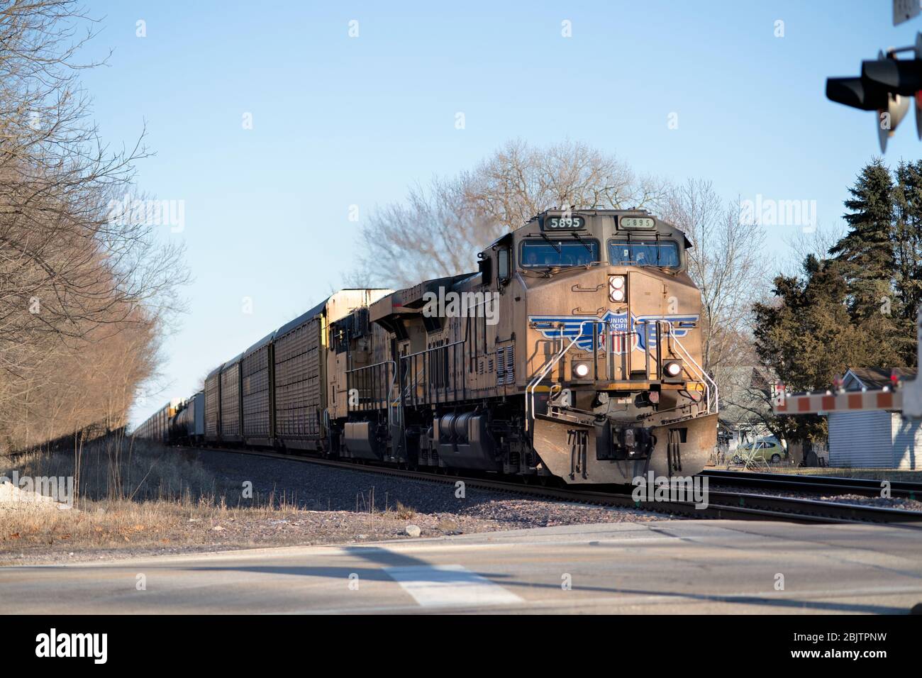 Maple Park, Illinois, États-Unis. Une locomotive Union Pacific à la tête d'un train de marchandises à l'approche d'un passage à niveau à Maple Park, Illinois. Banque D'Images