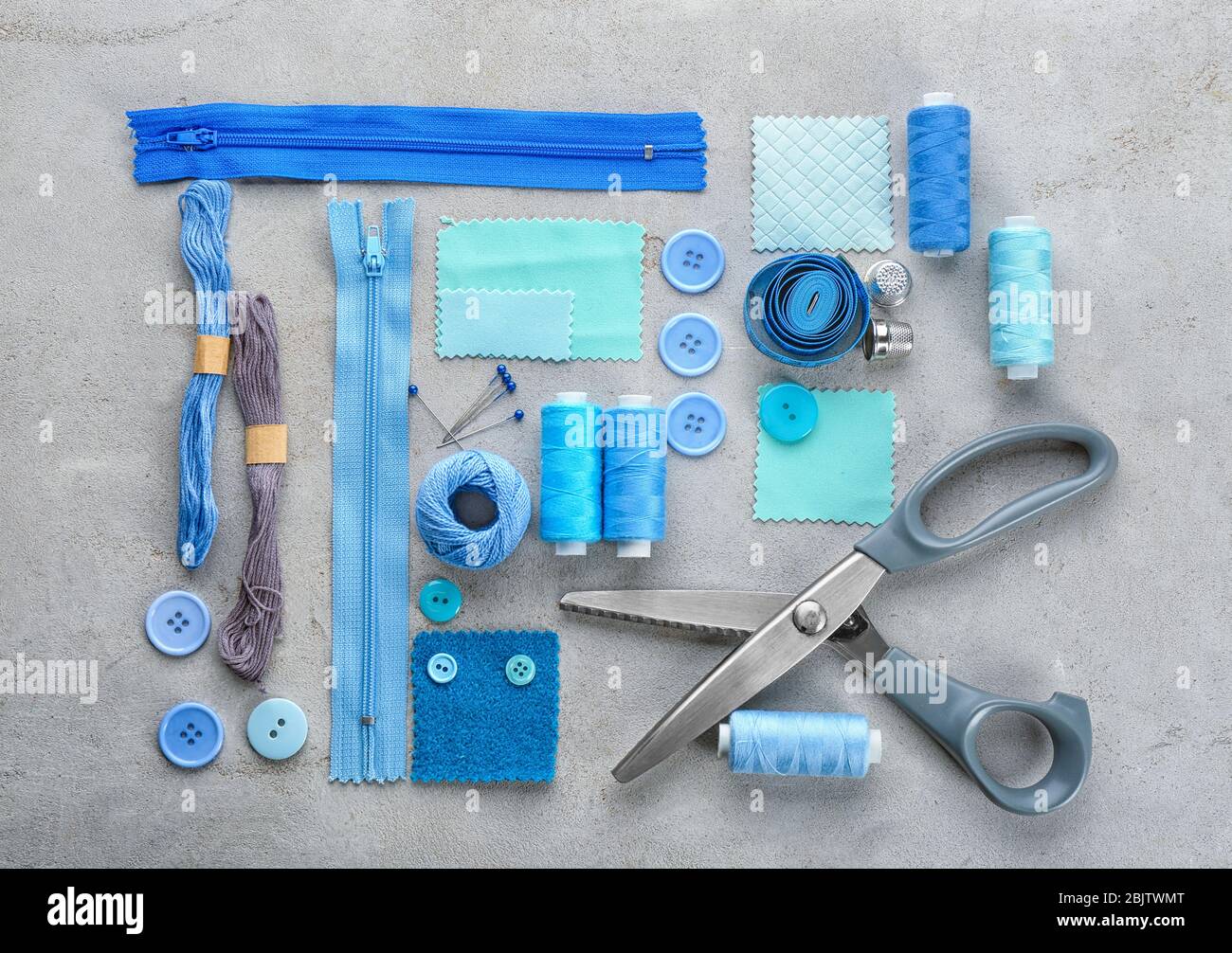 Composition avec fils à coudre et accessoires sur fond grunge, vue de dessus Banque D'Images