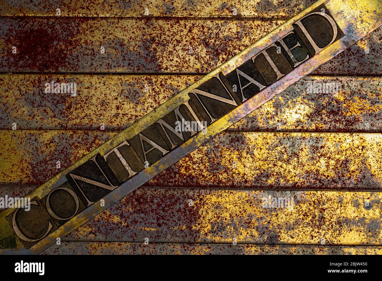 Photo de véritables lettres authentiques de composition formant du texte contaminé sur fond de cuivre et d'or texturé vintage avec de la poussière rouge Banque D'Images