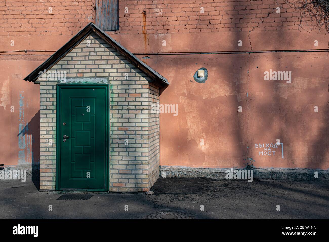 Porte vert foncé et toit en forme de triangle de porche dans un bâtiment rétro avec mur en stuc grunge et inscription « sortie pont » en russe. Segment Banque D'Images