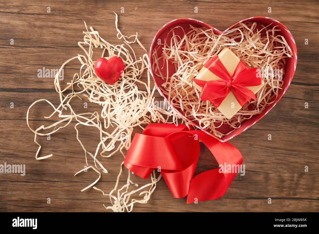 Boîte en forme de coeur avec paquet cadeau sur table en bois Banque D'Images