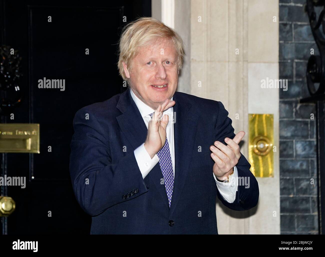 Le Premier ministre Boris Johnson à l'extérieur du 10 Downing Street à Londres se joint aux applaudissements pour saluer les héros locaux du Clap national de jeudi pour que les carrier reconnaissent et soutiennent les travailleurs et les soignants du NHS qui luttent contre la pandémie de coronavirus. Banque D'Images
