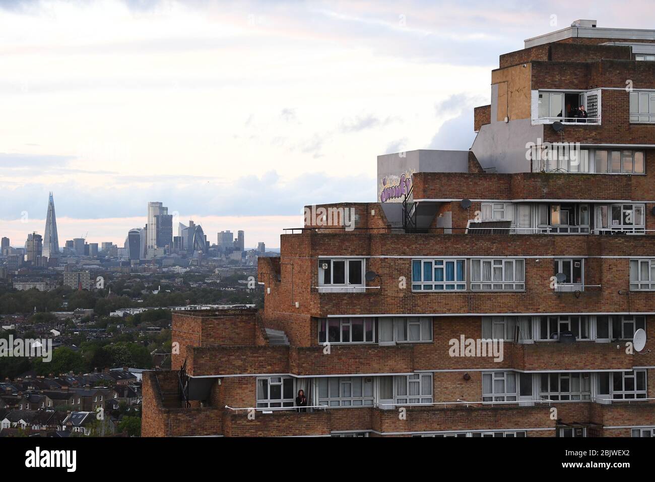 Les résidents d'un bloc d'appartements à Dawson's Heights, Dulwich, dans le sud de Londres, se joignent aux applaudissements pour saluer les héros locaux au cours du Clap national de jeudi pour que les soignants reconnaissent et soutiennent les travailleurs et les soignants du NHS qui luttent contre la pandémie de coronavirus. Banque D'Images