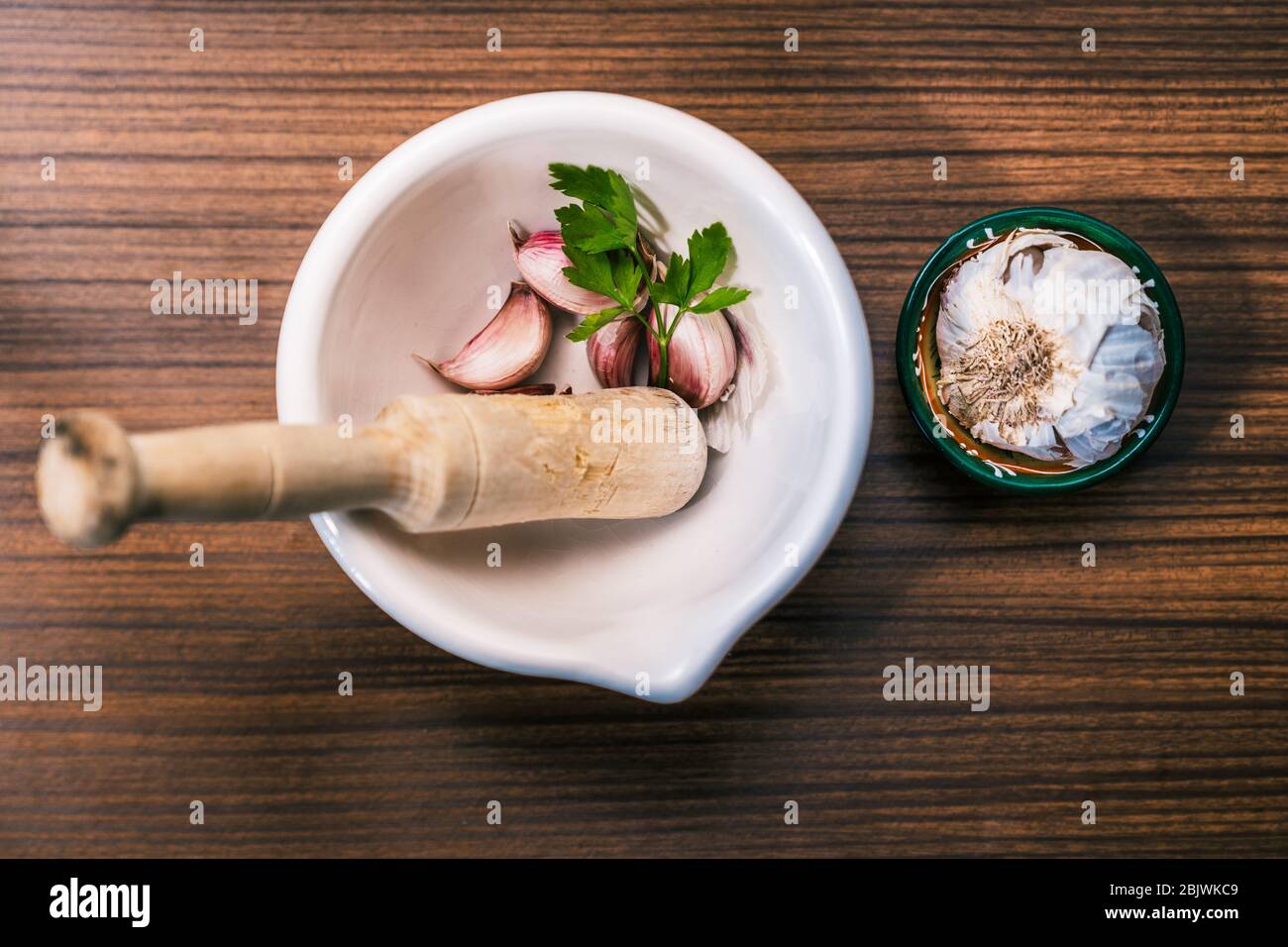 Préparer une recette pour faire des aioli de manière traditionnelle et maison. Ingrédients et ustensiles pour préparer l'huile d'ail. Gousses d'ail différentes, persil l Banque D'Images