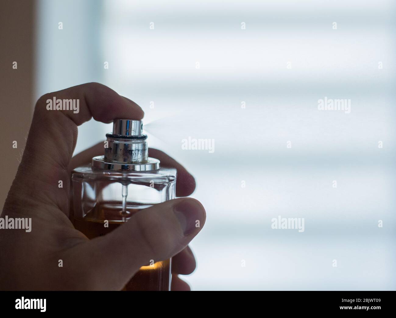 Pulvérisation de parfum à partir d'une bouteille en appuyant Banque D'Images