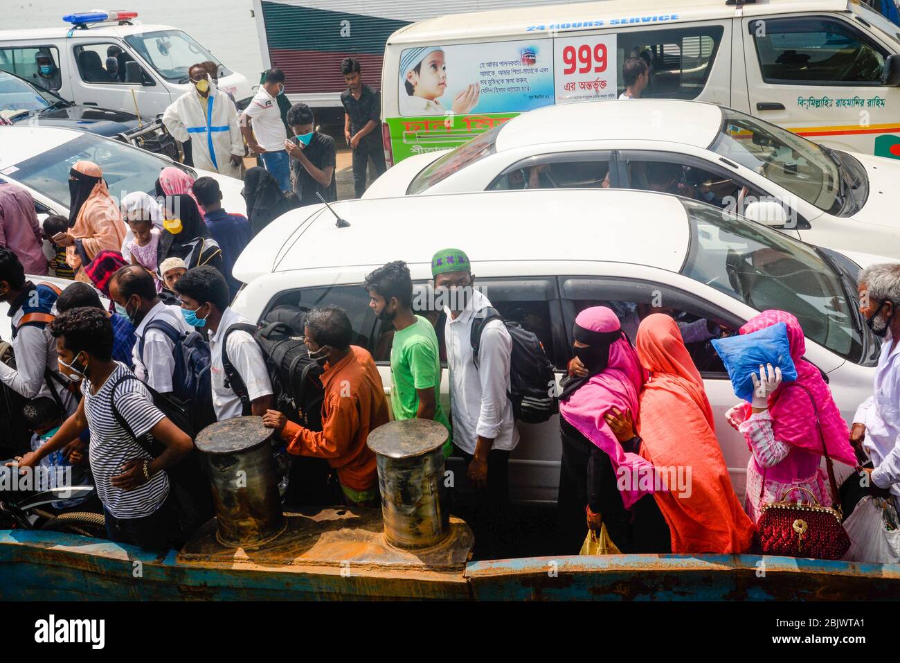 Les travailleurs migrants du vêtement débarquent d'un ferry après leur arrivée au ghat du ferry de Mawa. Le gouvernement du Bangladesh a assoupli les restrictions sur le transport et a rouvert les usines de vêtements en raison de la crise du coronavirus. Banque D'Images