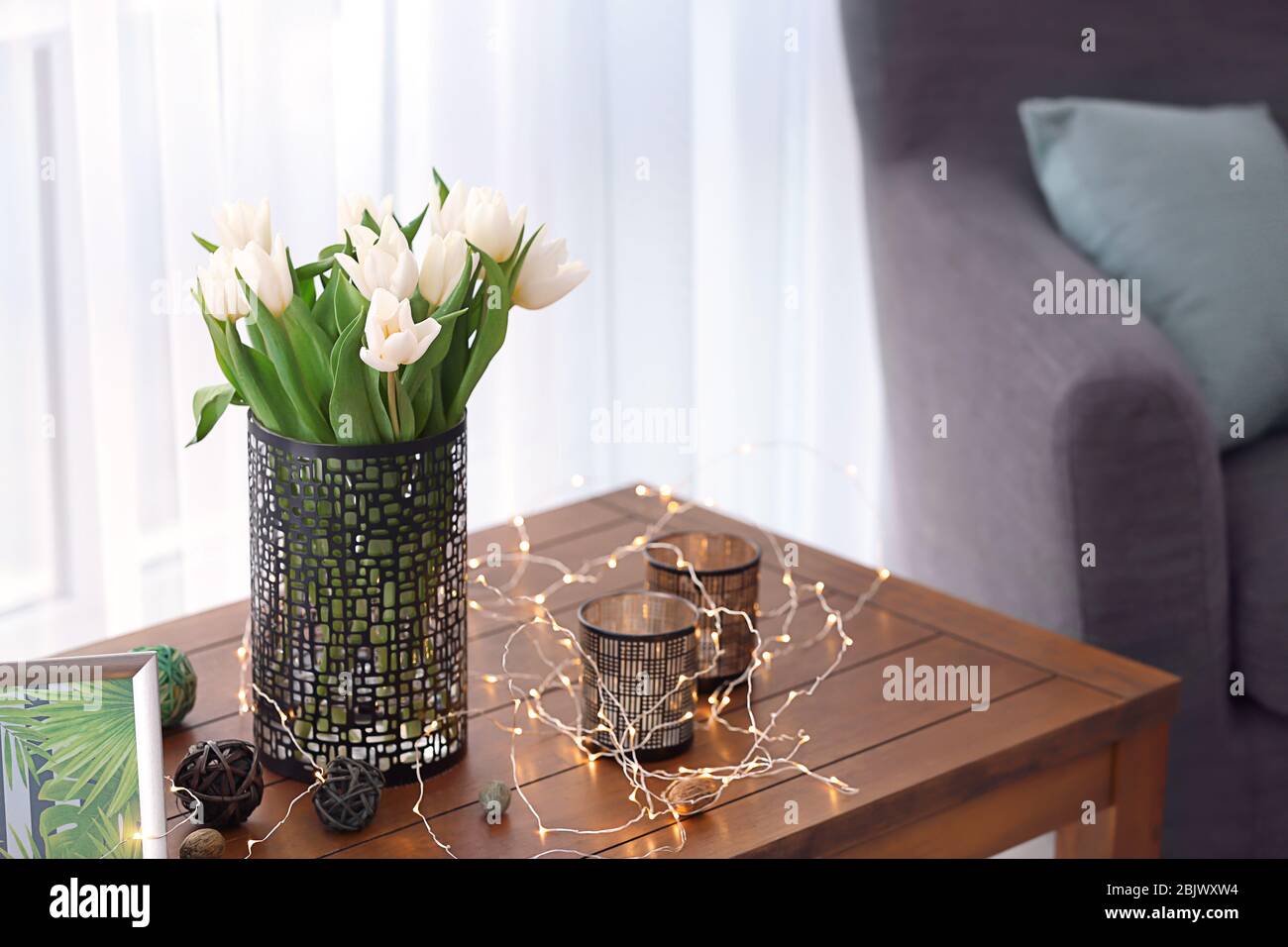 Table en bois avec bouquet de tulipes et décors dans le salon Banque D'Images