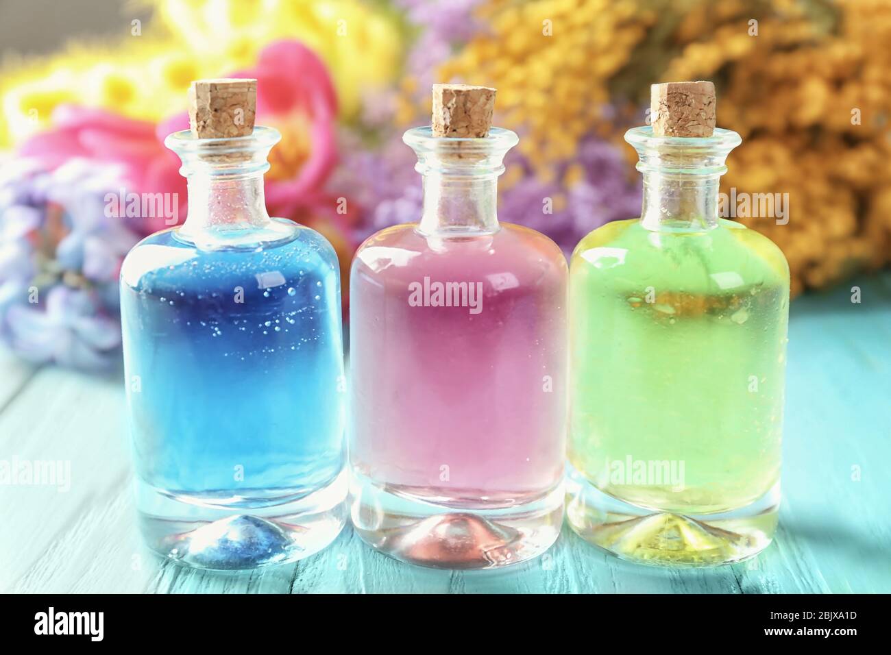 Bouteilles avec différentes huiles de parfum sur table en bois Banque D'Images