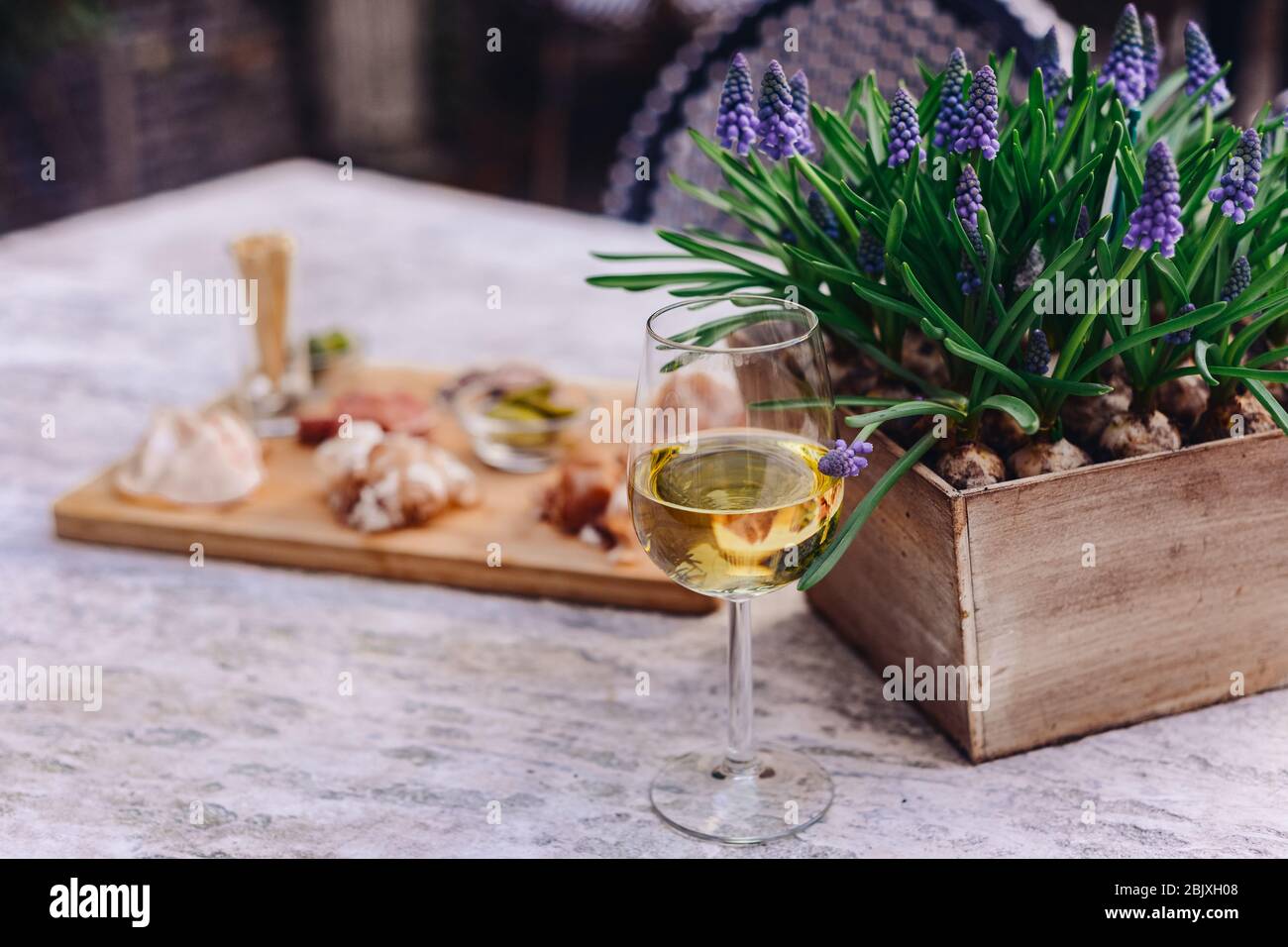 Amsterdam, pays-Bas. Verre de vin blanc à côté d'une fleur sur une table à l'extérieur dans un jardin Banque D'Images