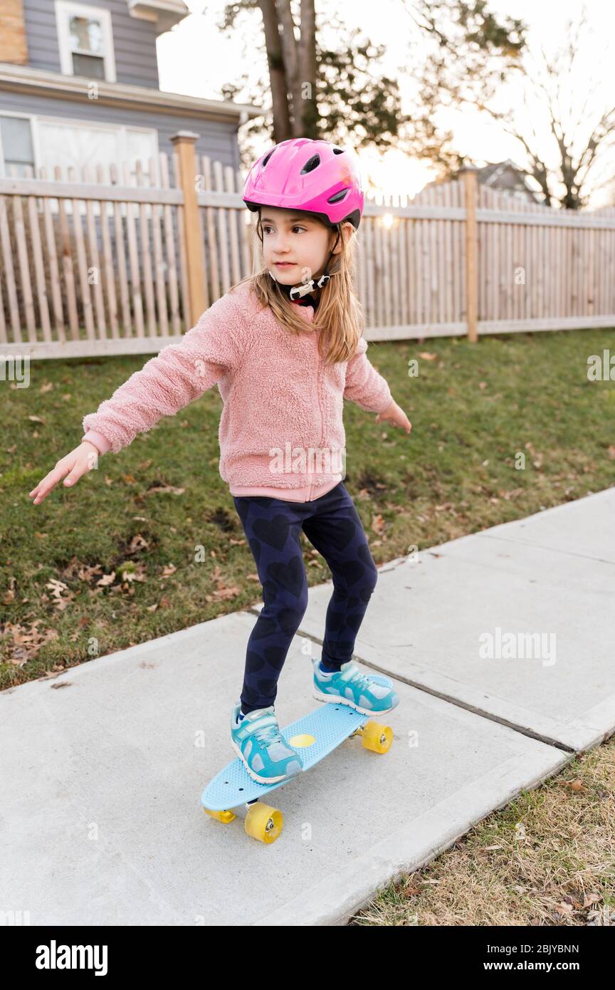 Une fille qui skate sur le trottoir Banque D'Images