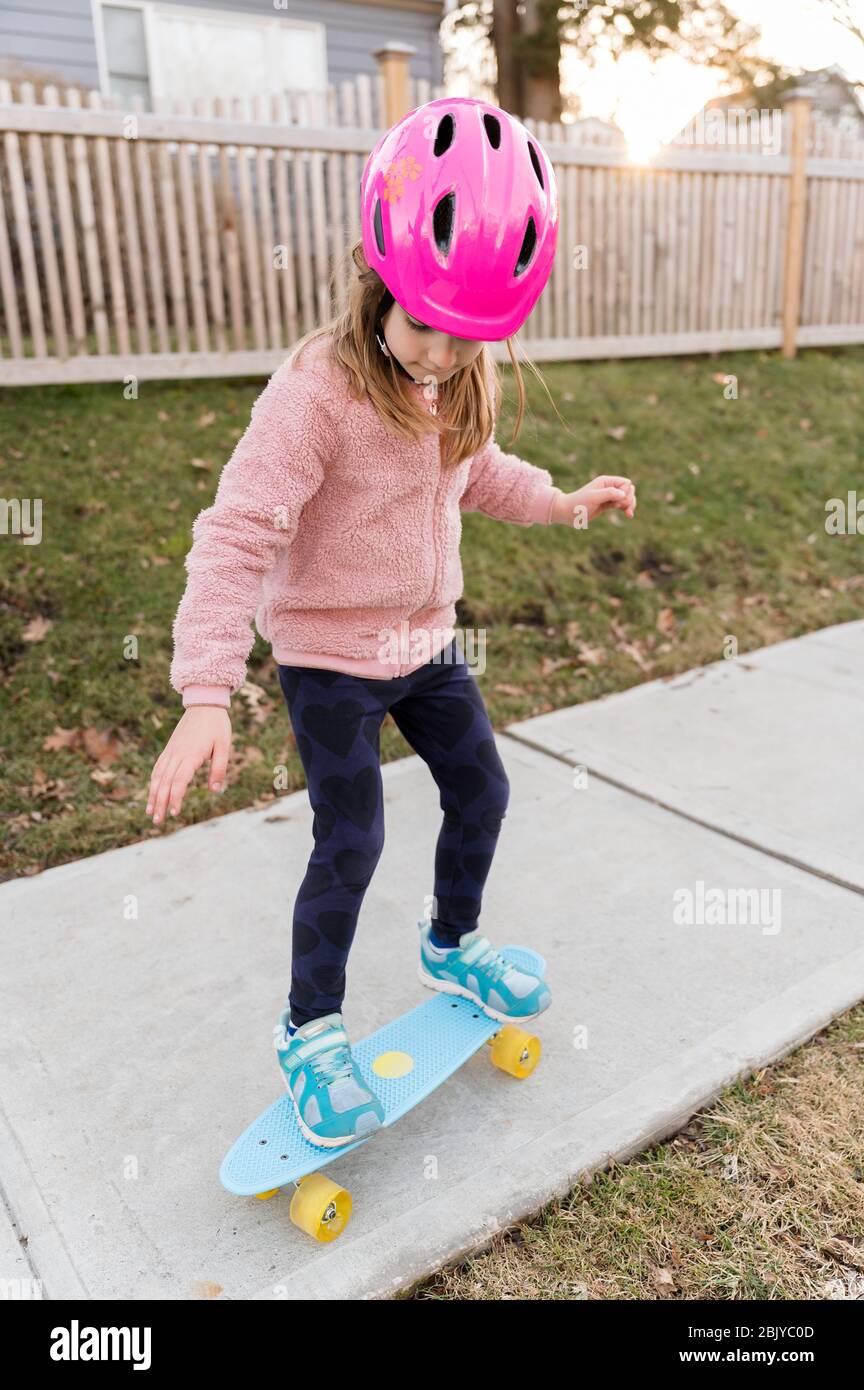 Une fille fait du skateboard sur un trottoir Banque D'Images