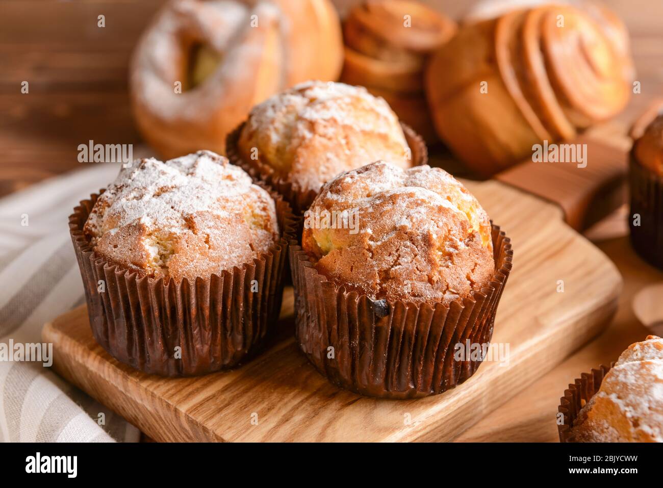 Muffins savoureux sur planche de bois, gros plan Banque D'Images