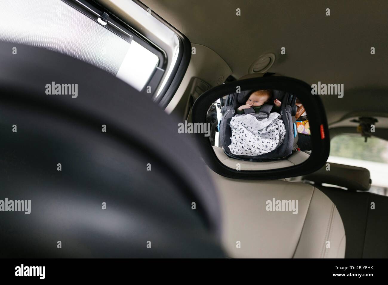 Réflexion de bébé garçon (2-3 mois)Â dans le miroir de voiture Banque D'Images