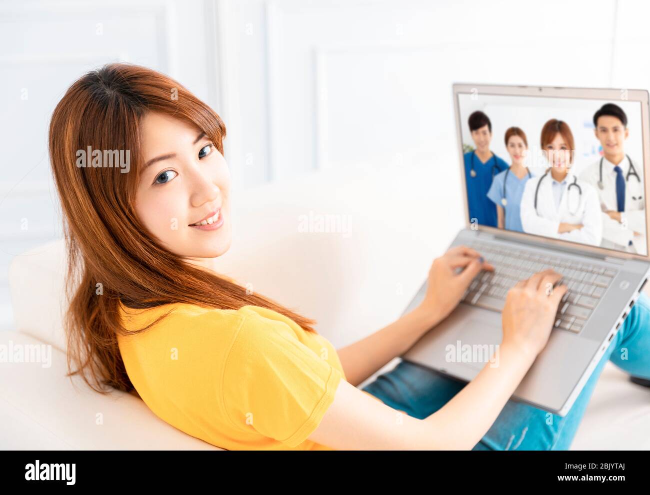 Jeune femme discussion vidéo avec un groupe médical sur ordinateur portable Banque D'Images