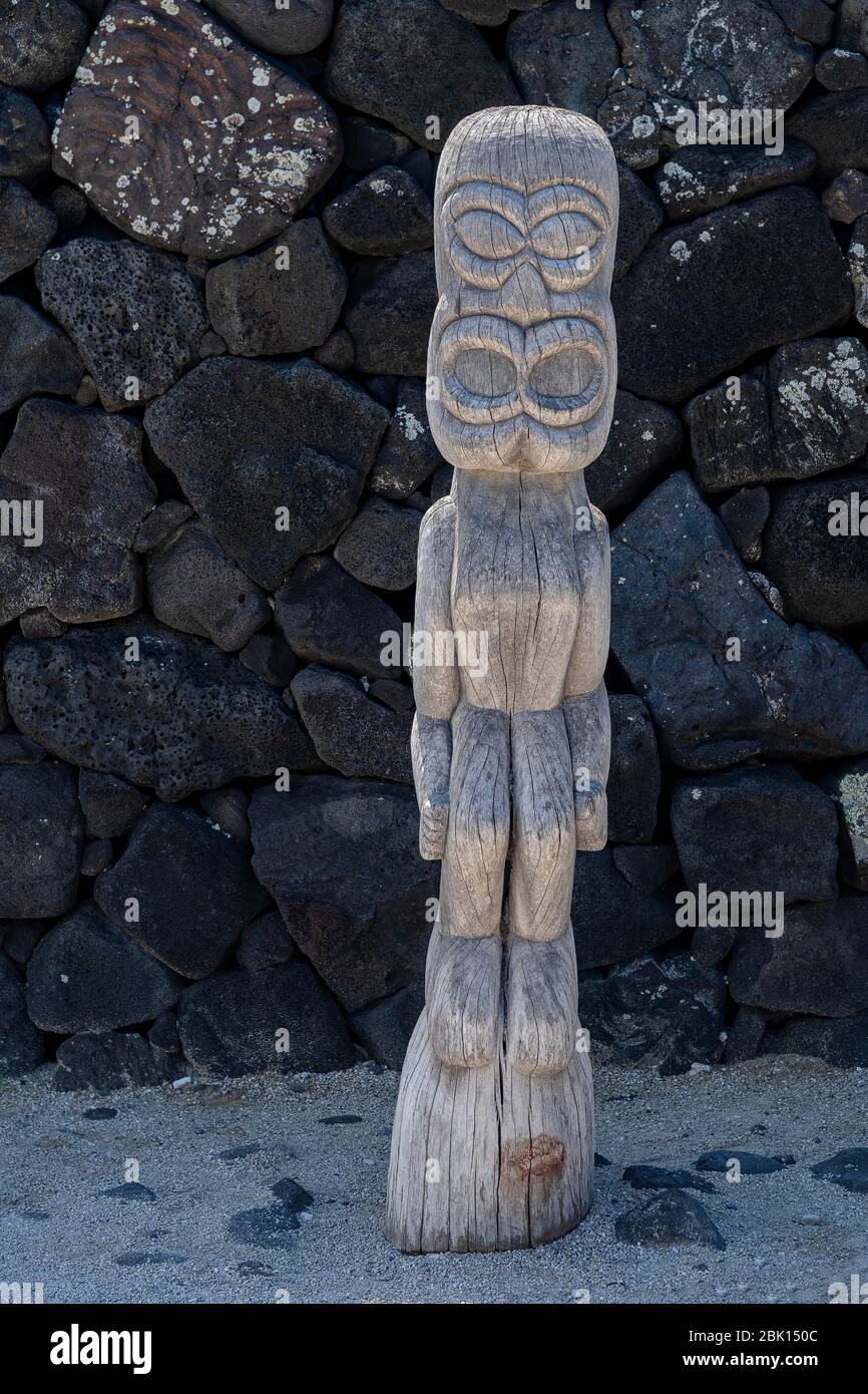Tiki, gardien en bois devant le mur de pierre de lave, pu'uhonua O Honaunau National Historical Park, Big Island, Hawaï Banque D'Images