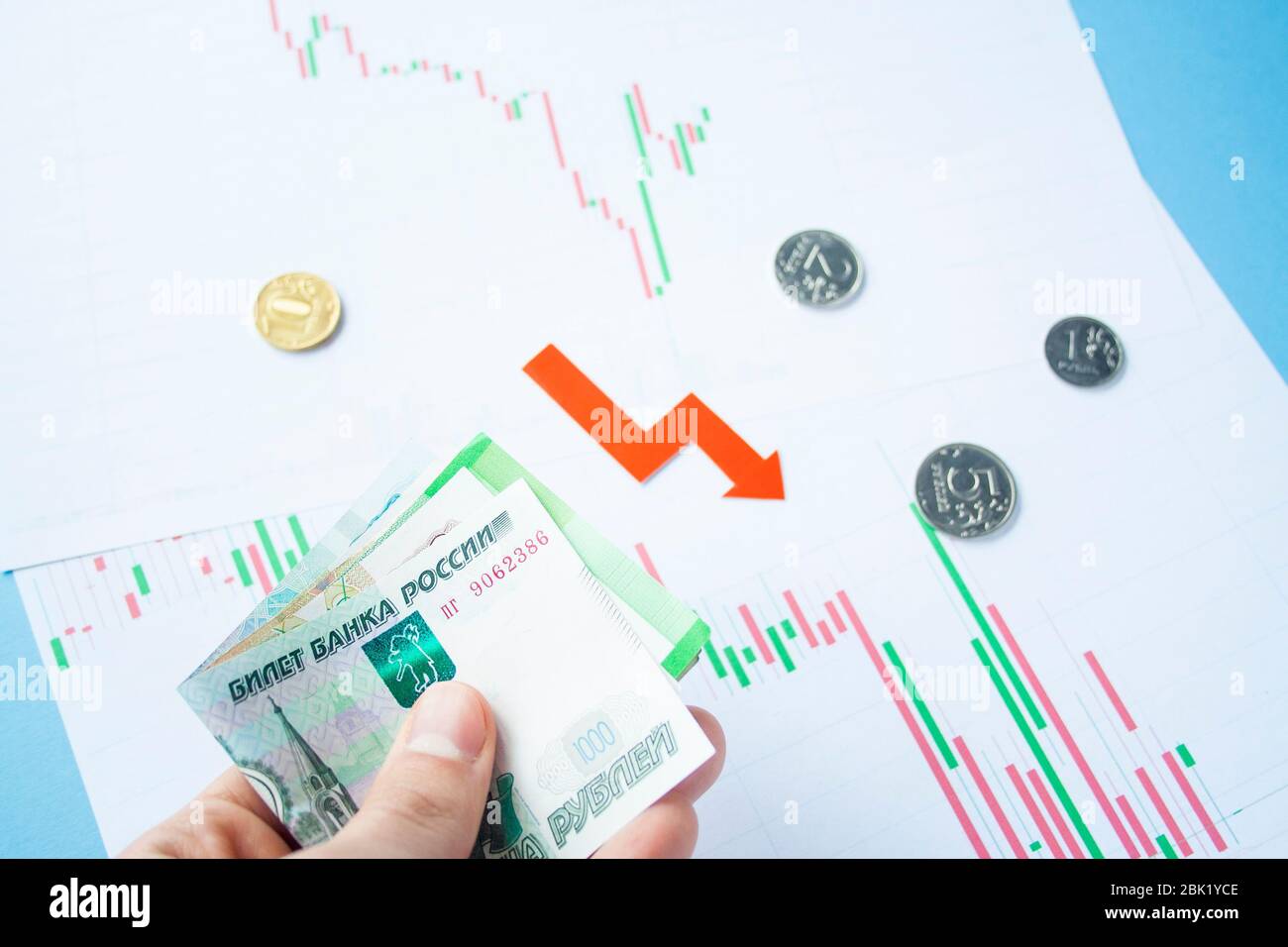 Main masculine tenant des factures roubles sur le taux de change du rouble russe et de la flèche rouge. Dépréciation rouble. Le taux de change du rouble chute. Rouble au dollar Banque D'Images