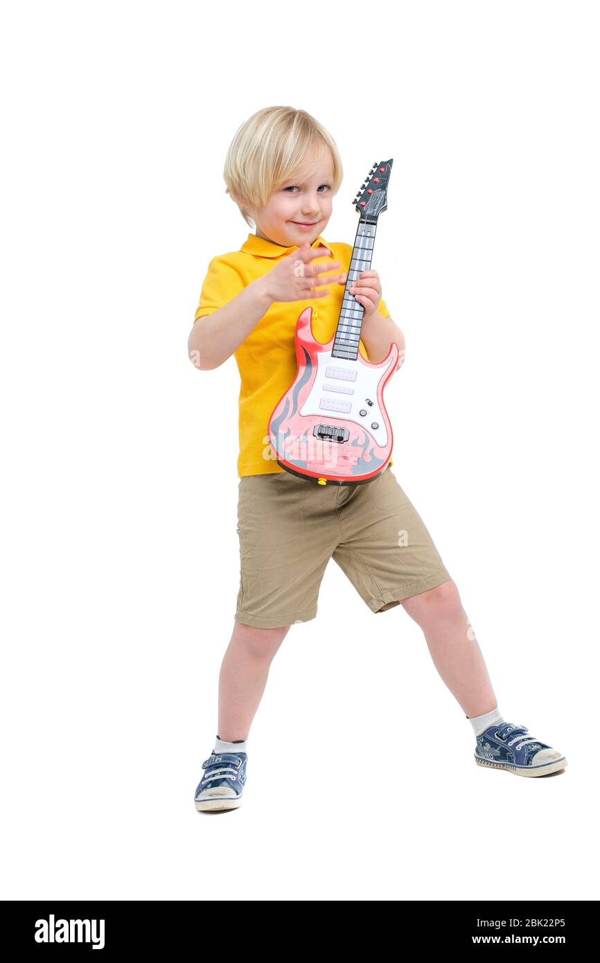 Garçon joue sur la guitare jouet isolée sur blanc Banque D'Images