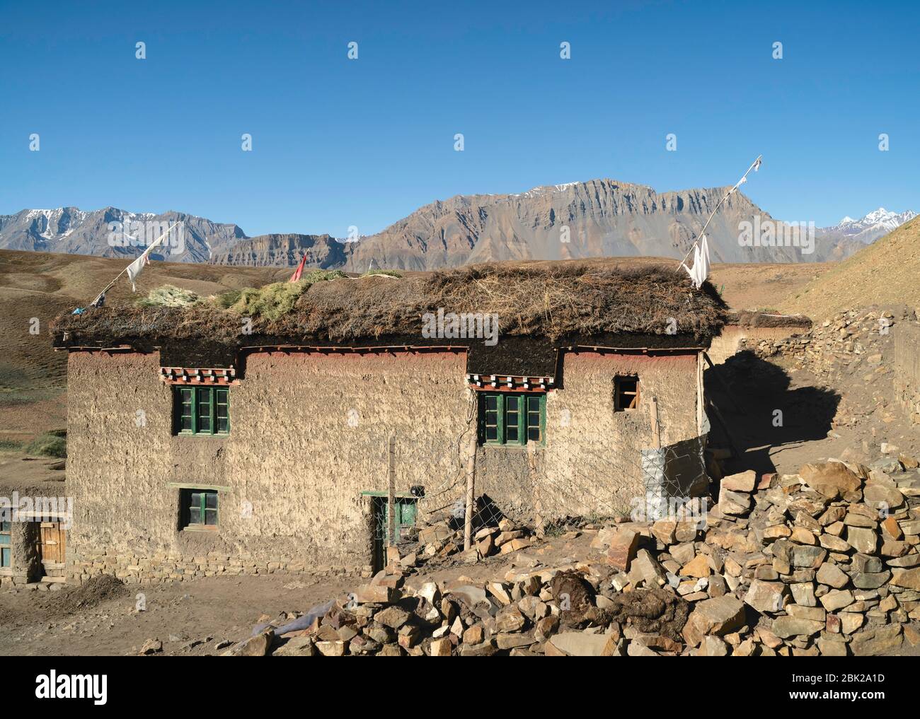 Maison traditionnelle avec plastré de boue et fourrage pour animaux se dessèchant sur le toit parmi les Himalaya dans un village isolé. KKomic, Inde. Banque D'Images