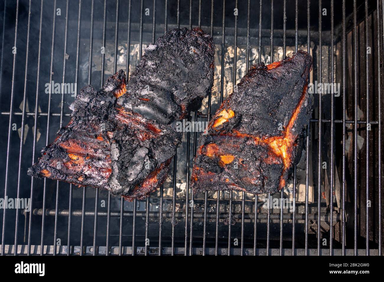 côtes de barbecue noires en ruines trop cuites sur le gril à charbon de bois . Banque D'Images