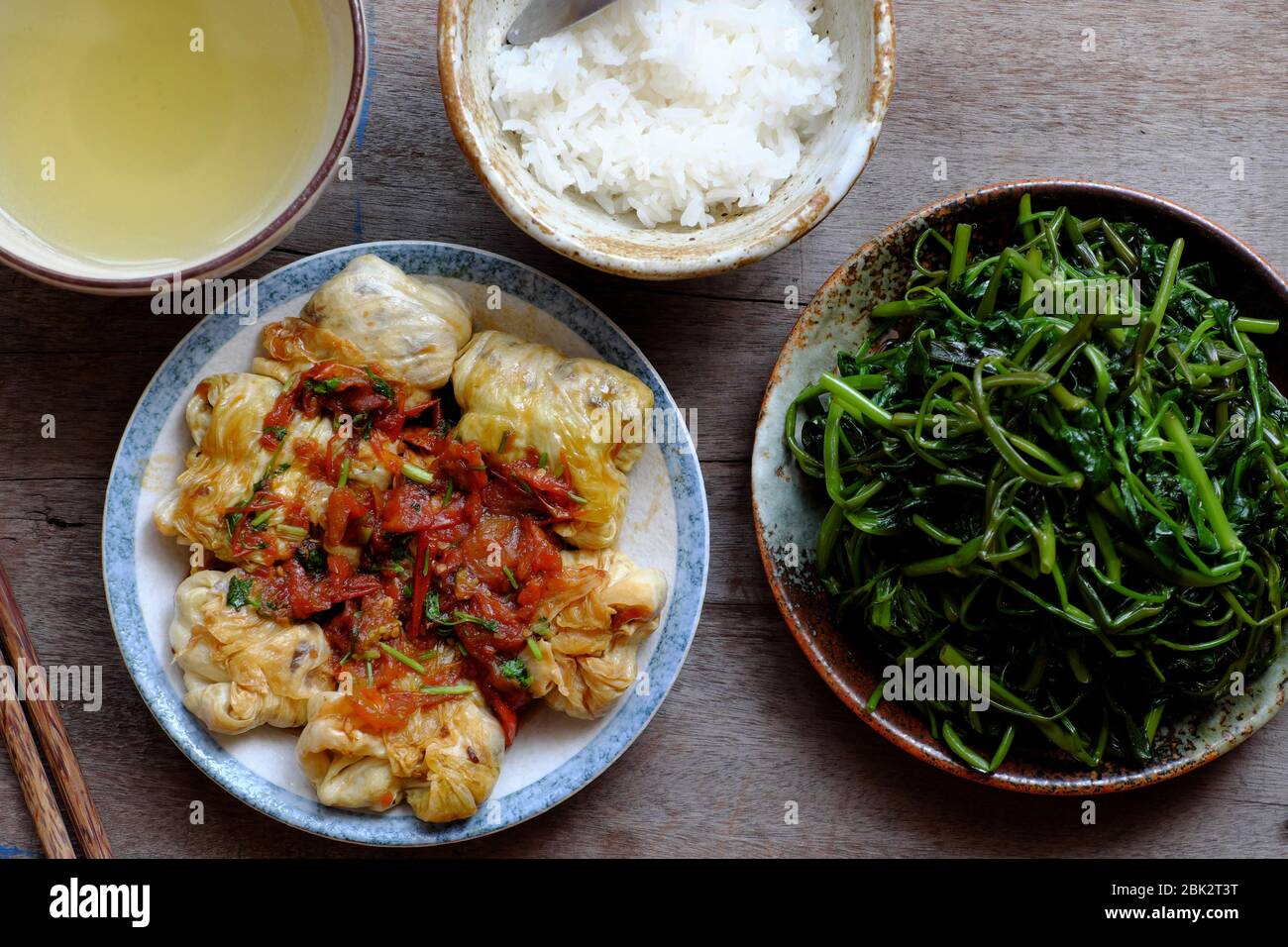 Repas végétalien vietnamien simple pour le déjeuner, épinards à l'eau bouillie, chou farci avec sauce tomate, bol de riz, nourriture saine qui riche en fibres Banque D'Images