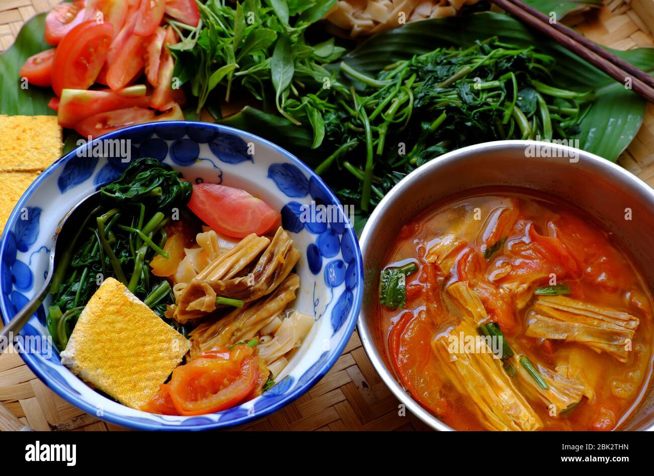 Plateau de nourriture petit déjeuner végétarien, soupe vietnamienne maison de nouilles de crêpes sèches, ingrédients eau épinards, tofu, tomate, riz sec nouilles, repas de végétalien Banque D'Images