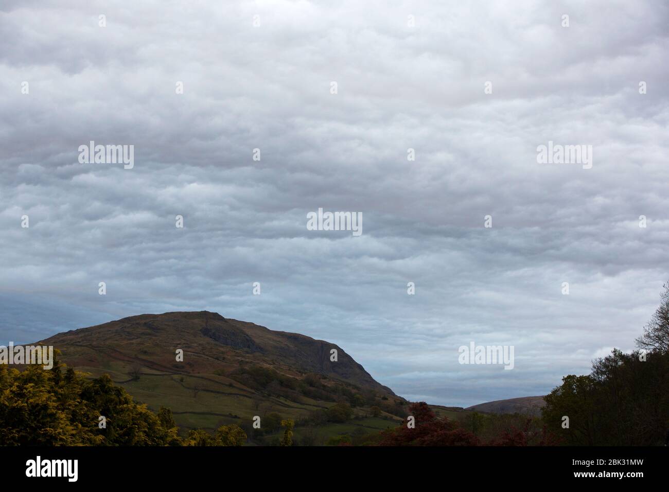 Les nuages se déforme sur un front occlusif au crépuscule au-dessus d'Ambleside dans le Lake District, au Royaume-Uni. Banque D'Images