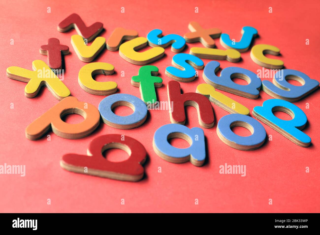 Alphabet anglais. Petites lettres anglaises en bois colorées sur fond rose. Banque D'Images