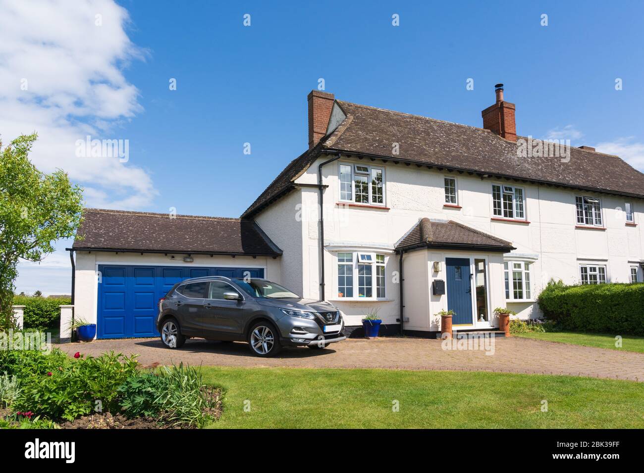 Extérieur d'une ancienne maison de conseil semi-indépendante des années 1920 avec porche supplémentaire, garage double et allée. Version sans voiture dans l'allée également disponible. Banque D'Images