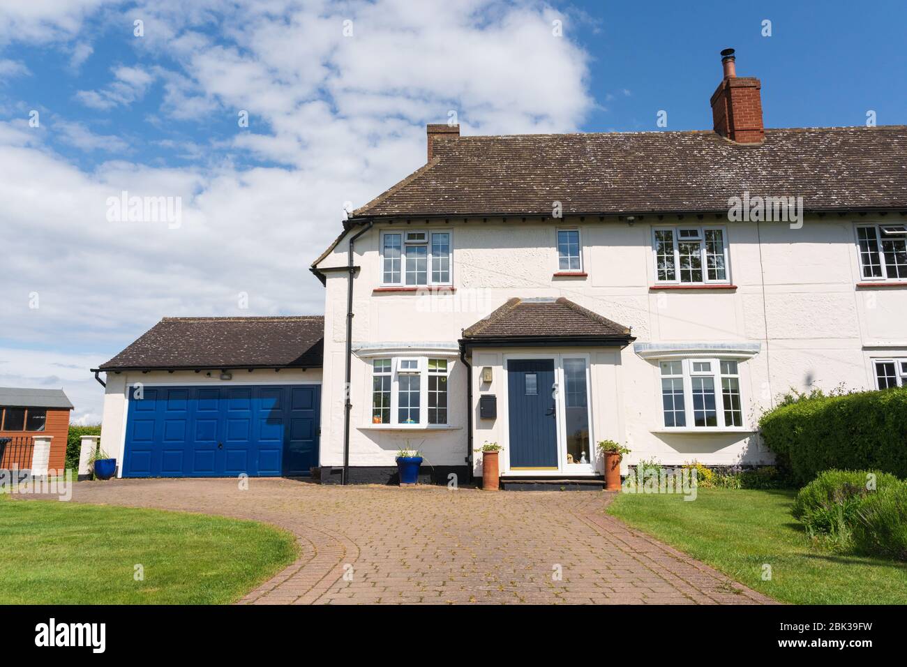 Extérieur d'une ancienne maison de conseil semi-indépendante des années 1920 avec porche supplémentaire, garage double et allée. Version avec une voiture dans l'allée également disponible. Banque D'Images