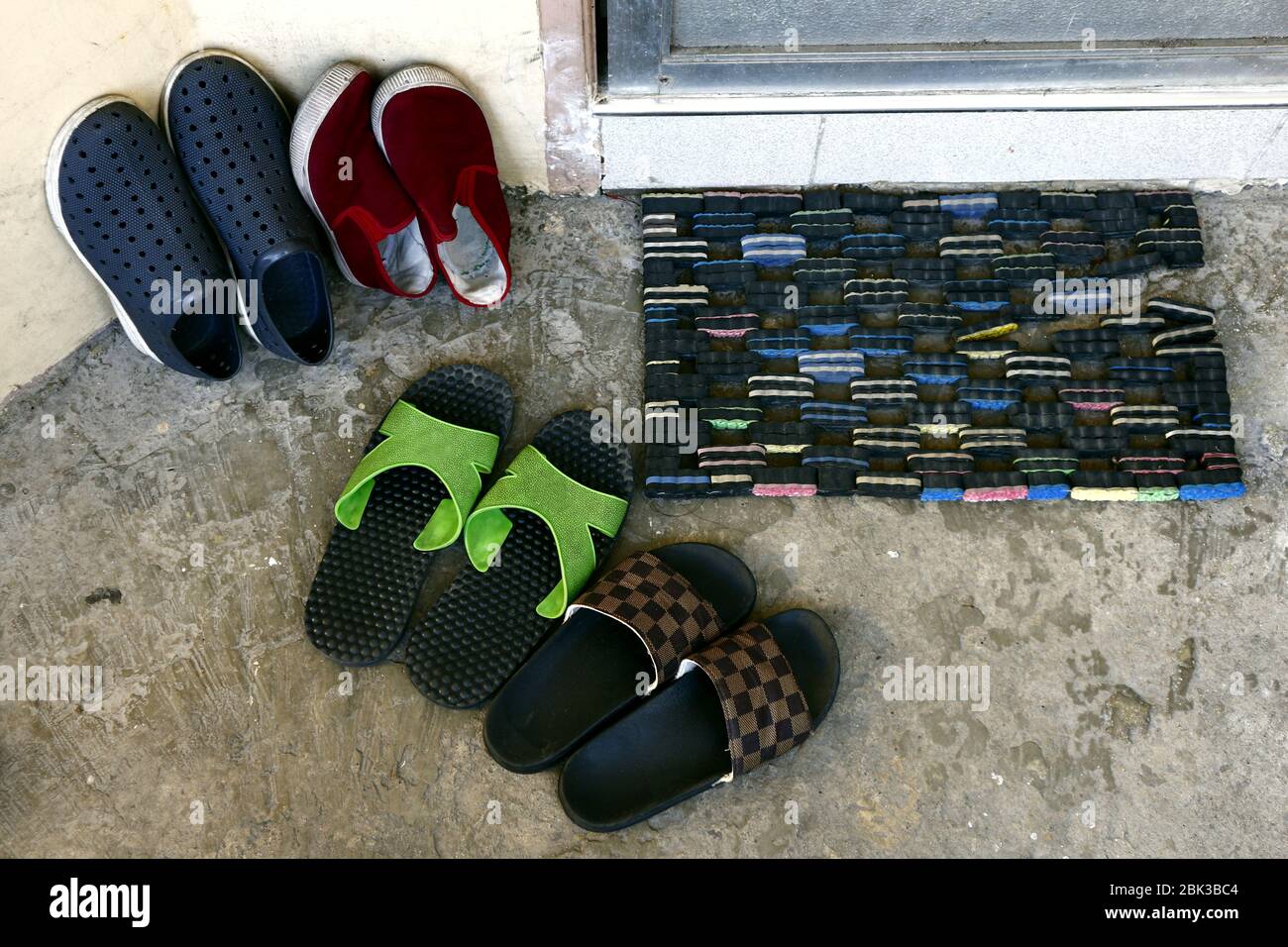 Photo de chaussures et de pantoufles sur la porte d'une maison. Banque D'Images
