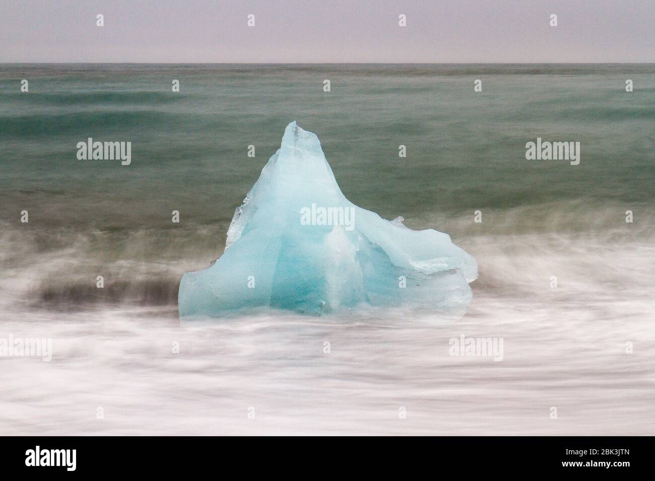 Longue exposition d'une des nombreuses pièces de glace sur la plage de diamants de Jökulsárlón, dans le sud de l'Islande. Banque D'Images