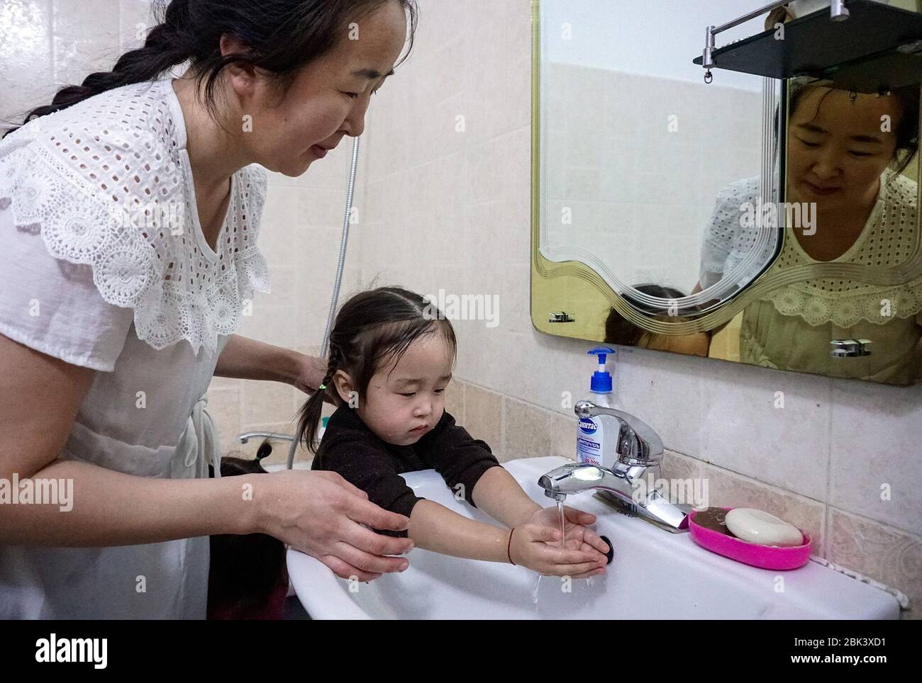 Javzandulam Purevjav et ses enfants ont fait un lavage des mains régulier une partie de leur journée. Non seulement la famille est restée à l'abri du coronavirus, mais les enfants ont également échappé à des rhumes, des grippes et des infections intestinales réguliers qui sont fréquents cette période de l'année. (Khorloo Khukhnohoi, GPJ Mongolie) Banque D'Images