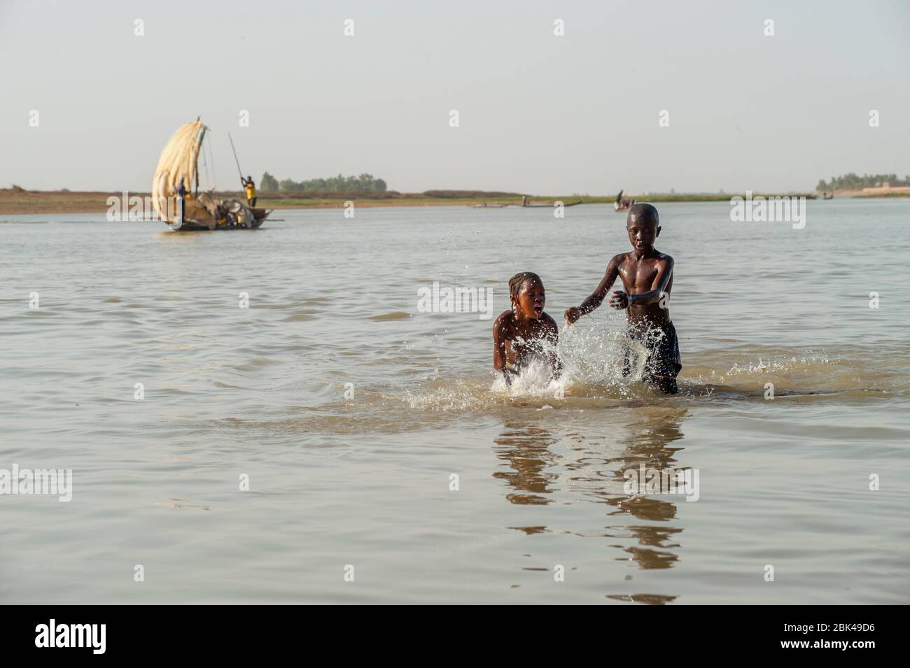 Un garçon et une fille jouent et éclabousse dans l'eau de la rivière Bani à Mopti au Mali, en Afrique de l'Ouest. Banque D'Images