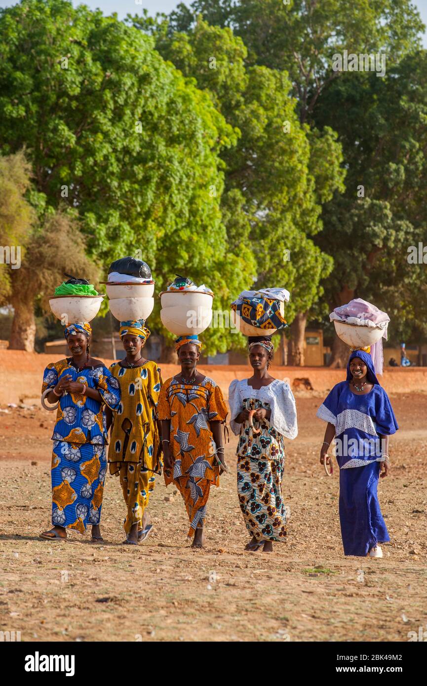 Les femmes de la région marchant et portant la lessive sur leur tête sur le rivage de la rivière Bani à Mopti au Mali, en Afrique de l'Ouest. Banque D'Images