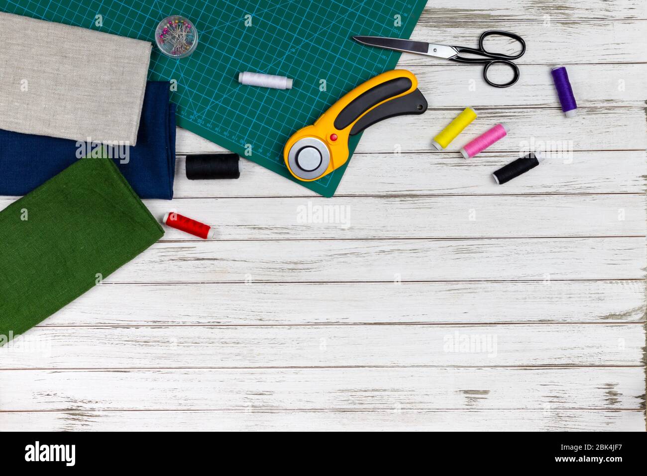 il y a des outils de courtepointes, de broderie et de couture sur la table. couteau patchwork, ciseaux, tapis de coupe doublé, auto-verrouillage, fils, ruban de mesure, flo Banque D'Images il y a des outils de courtepointes, de broderie et de couture sur la table. couteau patchwork, ciseaux, tapis de coupe doublé, auto-verrouillage, fils, ruban de mesure, flo Banque D'Images