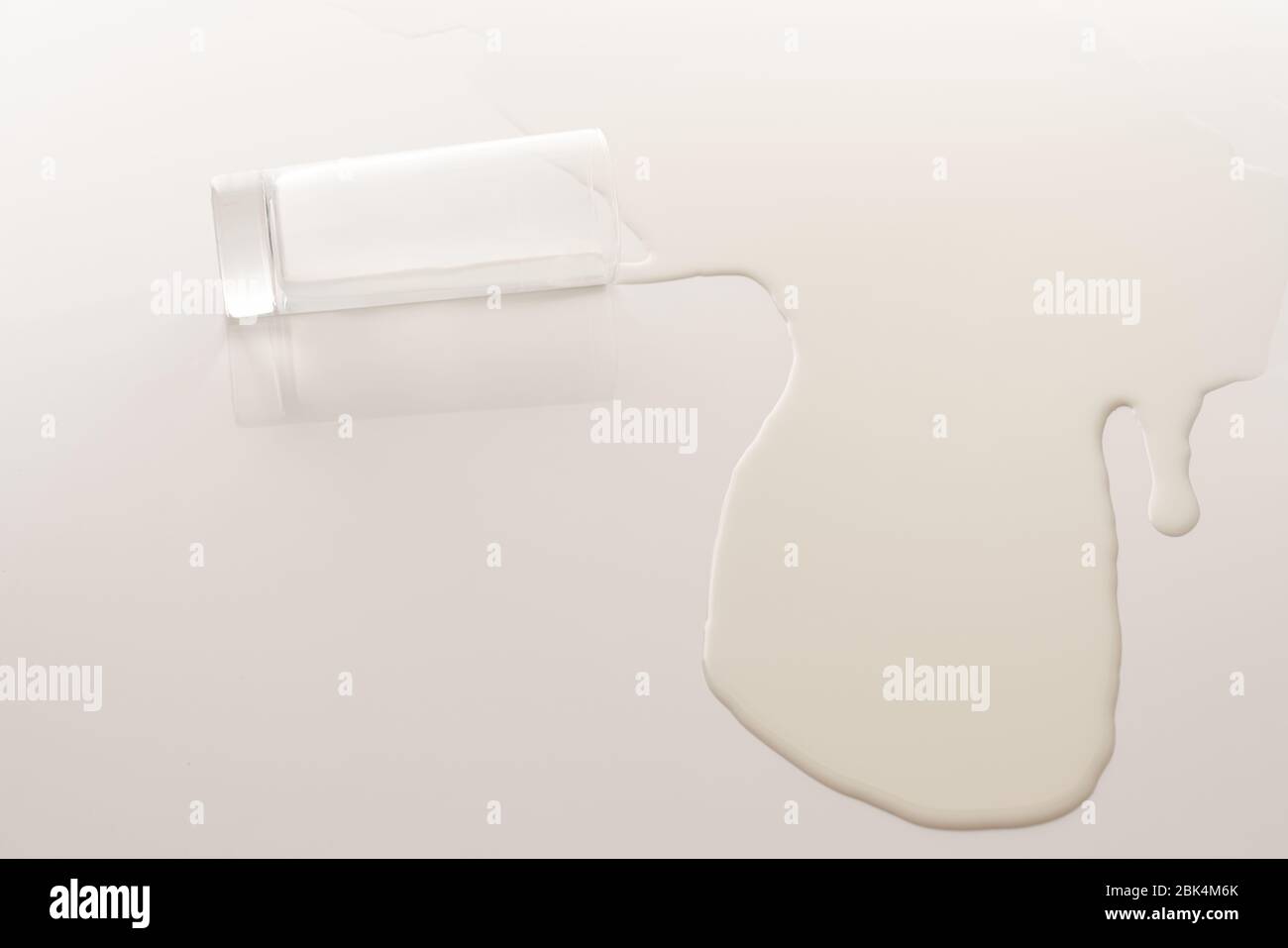 Lait renversé à partir d'un verre sur la table blanche Banque D'Images Lait renversé à partir d'un verre sur la table blanche Banque D'Images