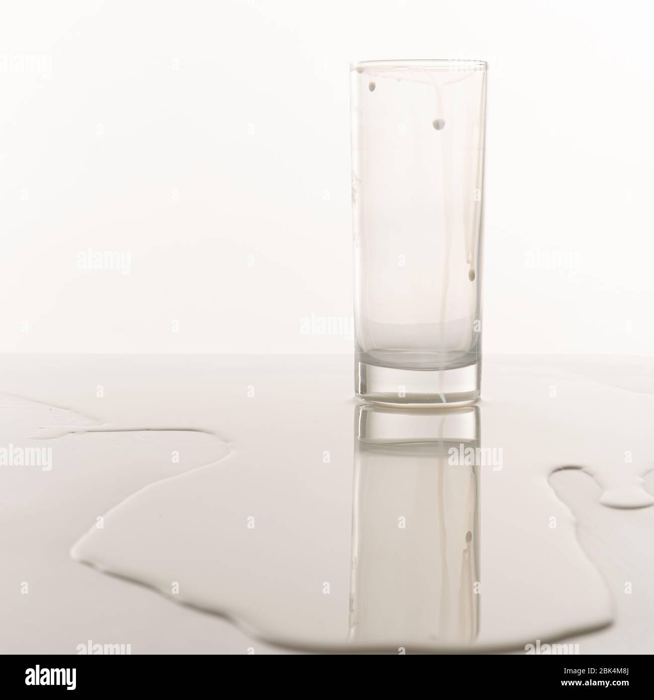Vider les supports en verre du lait renversé sur la table Banque D'Images Vider les supports en verre du lait renversé sur la table Banque D'Images