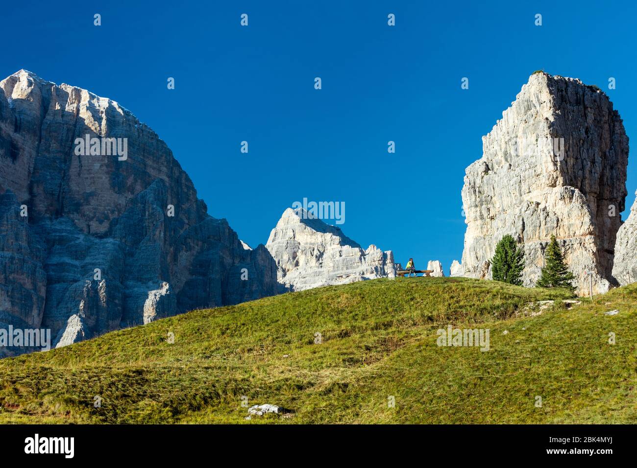 Homme sur un téléphone cellulaire avec Tofana di Rozes et les Dolomites qui dominent près de Cortina d'Ampezzo, Vénétie, Italie Banque D'Images