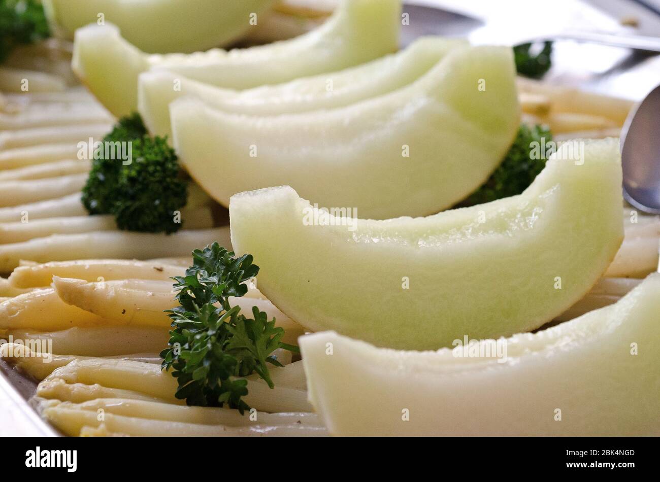 Melons de miel et asperges magnifiquement présentés sur un plateau Banque D'Images