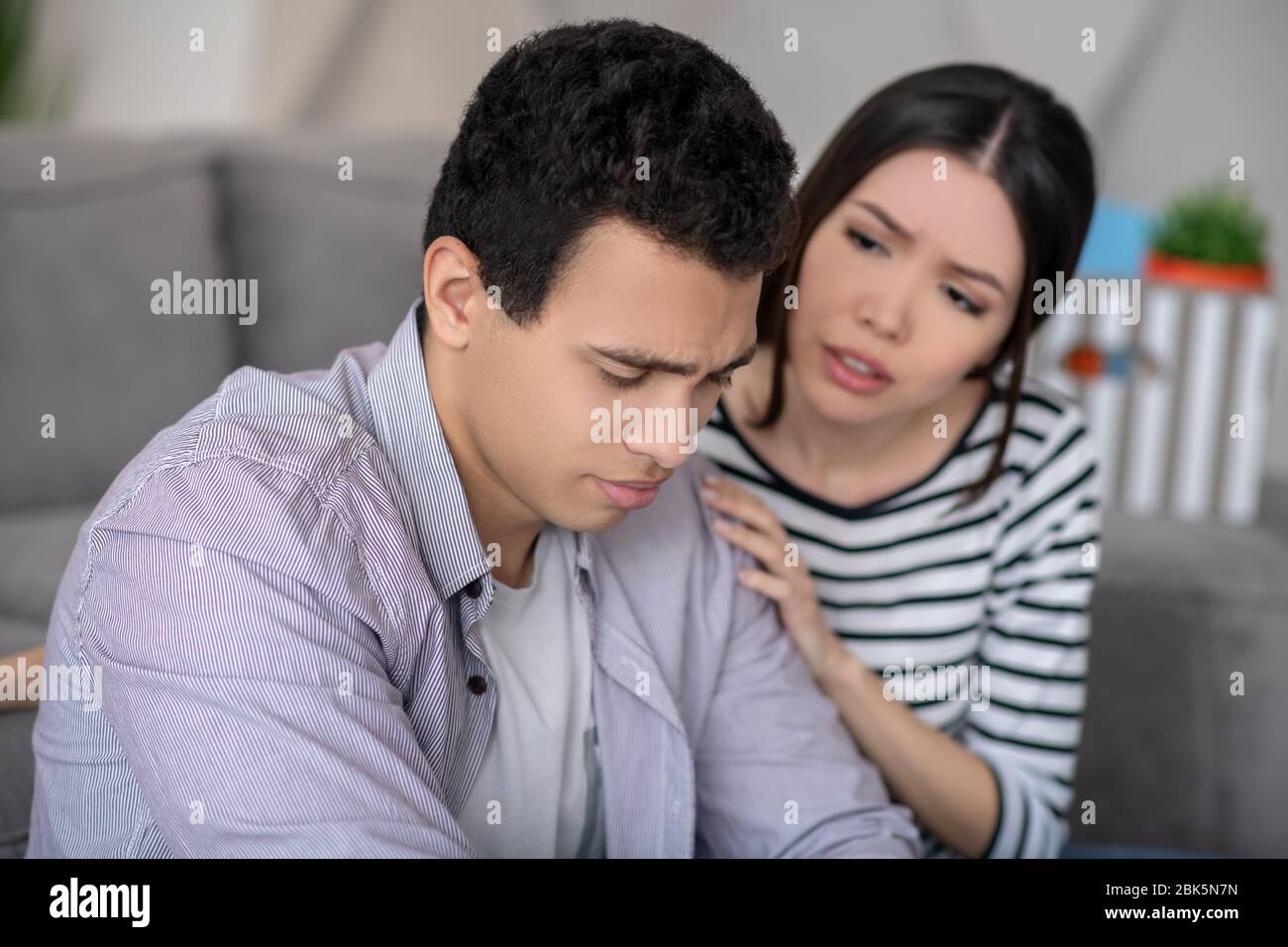 Jeune homme aux cheveux sombres, d'une triste humeur et d'une femme. Banque D'Images