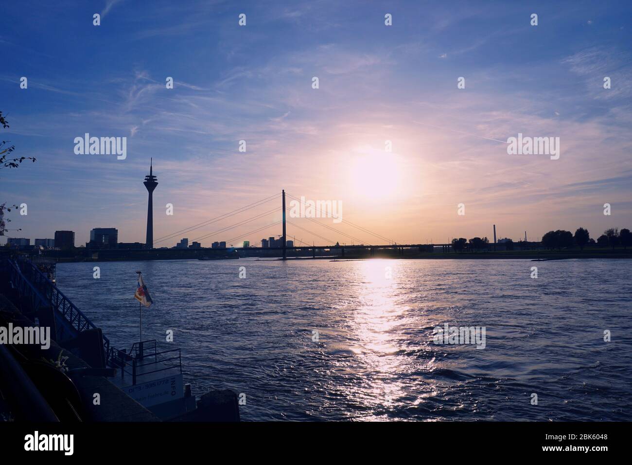 Vue panoramique sur la ville avec coucher de soleil romantique sur le Rhin à Düsseldorf avec les deux sites de la tour du Rhin et du Rheinsniebrücke. Banque D'Images