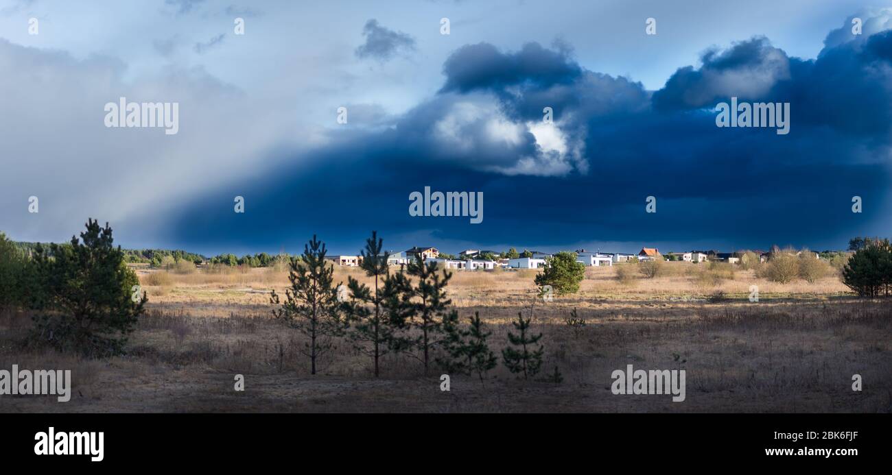 Une grande neige bleu foncé nuage de neige au-dessus d'une petite ville éloignée Banque D'Images