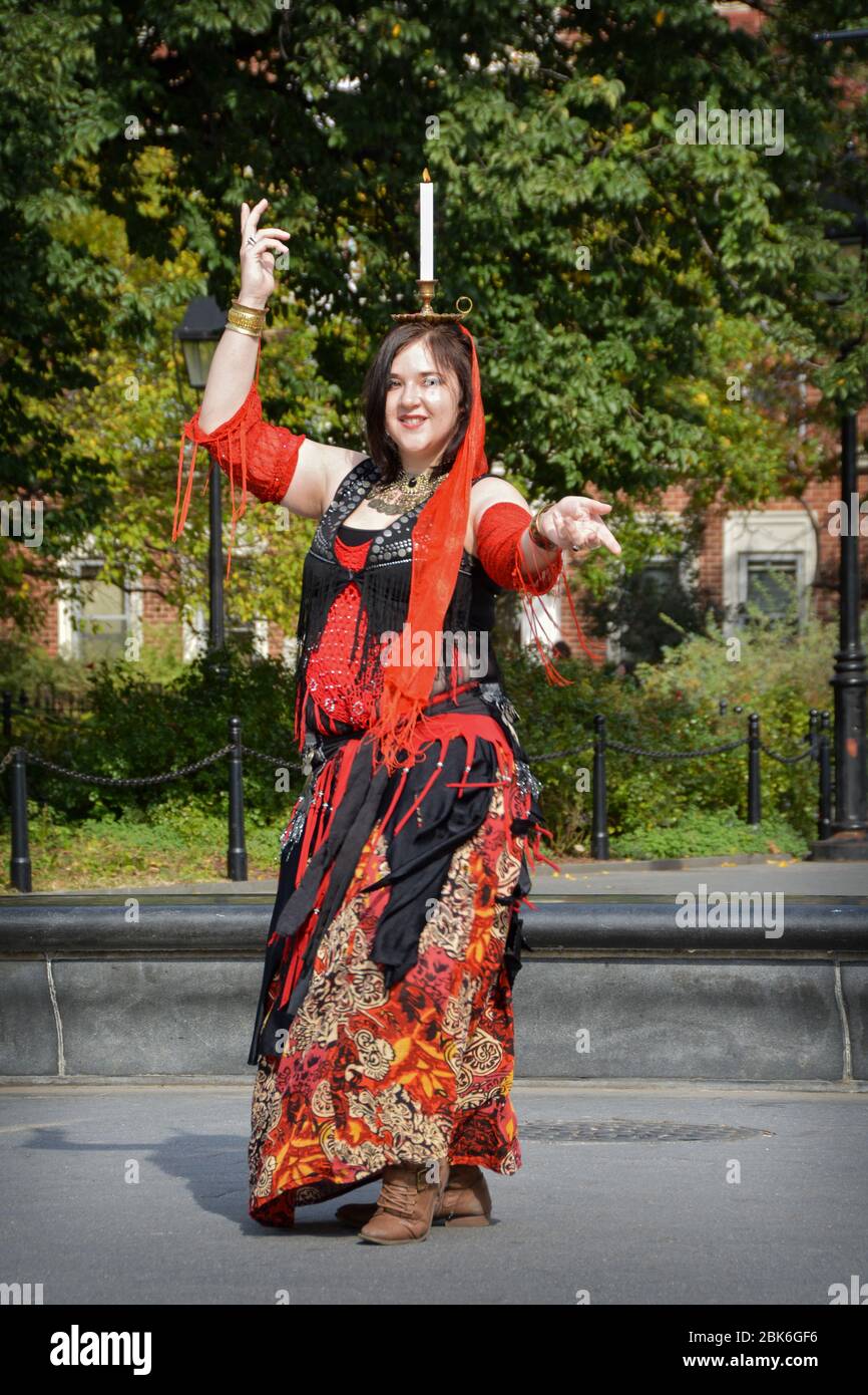 Une femme bellydancing tout en équilibrant une bougie sur sa tête à Washington Square Park à Greenwich Village, New York City. Banque D'Images